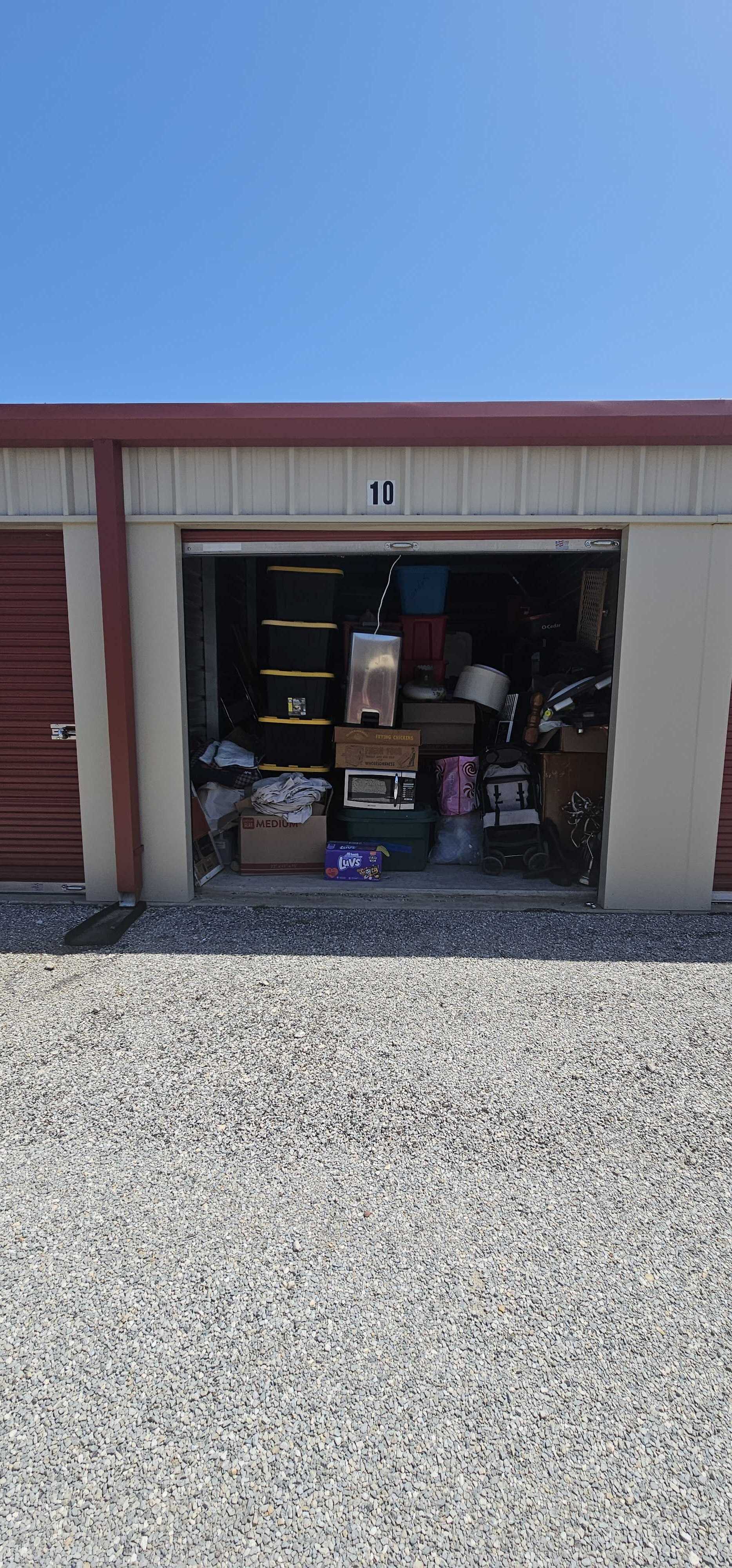 Open storage unit filled with household items, boxes, and totes at Caddo Mills Climate Storage in Texas
